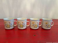 Four matching floral mugs side by side showing exterior pattern