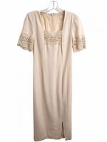 Front view of cream sheath dress displaying lace bodice, square neckline and front slit