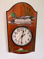 Front view of wall clock showing full plaque and artwork