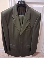 Olive green suit jacket on hanger