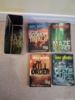 Four Maze Runner novels and empty slipcase arranged front covers facing up
