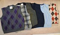 All six sweater vests laid side by side