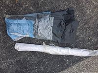 Black WeedBlock fabric folded with packaging and white felt roll wrapped in plastic