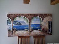 Full view of horizontal canvas painting on wall above chairs