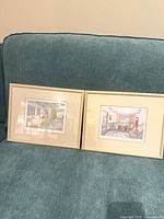 Both framed prints side by side on couch