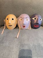 Front view of three Hay paper mâché masks