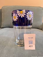 Front view of cobalt blue glass vase with painted daisies