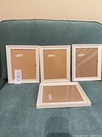 Four white IKEA Sondrum frames displayed upright and flat showing front and glass