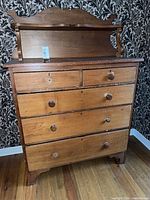 Front view of dresser showing five drawers and missing knobs