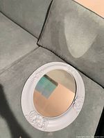 Front view of the oval mirror on sofa showing full frame