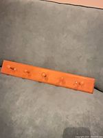 Front view showing full length of pine shelf with five pegs
