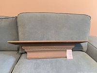 Front view of painted wooden shelf on couch