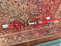 Full view of one ski showing overall graphics and mounted bindings