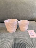 Two milk glass hobnail vases side by side with size tag
