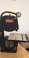 Front view of Ryobi BS903 9-inch bandsaw showing brand logo, lamp and table