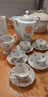 demi-tasse cups, saucers, coffee pot, creamer grouped on table