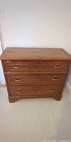 Front view of wooden chest with three drawers