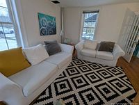 Loveseat and ottoman area showing slipcover and pillows