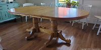 Full view of assembled oak dining table with both leaves inserted