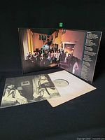 Gatefold open showing inner artwork, record in lyric sleeve, poster beneath