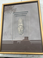 Front view of framed mask sculpture with signing visible