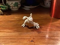 Front view of pearl Mega Mewtwo X figurine on wooden surface