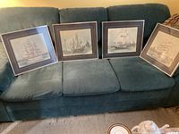 All four framed Ben Babelowsky ship prints on sofa