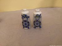 Front view showing both shakers with figural graphics