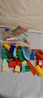 Clear zip bag containing mixed Mega Bloks bricks and six figures on table