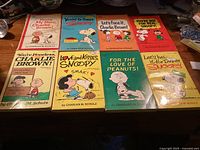 Front covers of all eight Peanuts paperback comic books