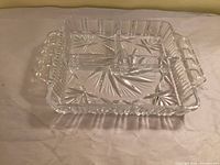 Oblique view of square crystal dish showing three sections and handles