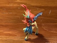 Front view of Takaratomy Keldeo Pokémon figure standing on wooden surface