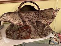 Front view of tapestry travel bag showing handles and pattern