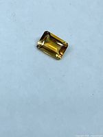 Top view of emerald-cut golden yellow citrine on neutral background