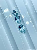 Three pear-shaped aquamarine gems side by side