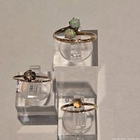 All three rings on acrylic stands showing stone settings and overall design