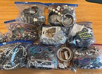 Nine zip bags filled with various costume jewellery pieces spread on table