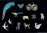 Front view of all thirteen animal-themed jewellery pieces on black background