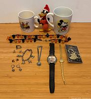 overview of mugs, figure, beaded necklace, watches, packaged jewelry, assorted loose jewelry