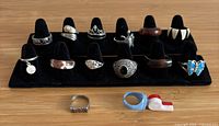 Group image of all rings on display stand plus three additional rings laid flat