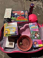 Open suitcase showing multiple toys, pop-it, puzzle, socks box, pig bank
