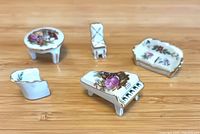 Five porcelain miniature furniture pieces front view
