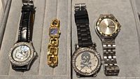 Group shot of four wristwatches in tray