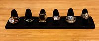 Front view of six rings on black velvet display