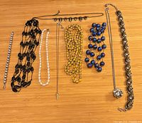 All nine necklaces laid out on wood surface