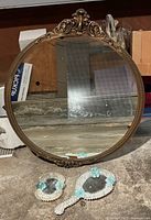 Front view of round wall mirror with two small vanity mirrors beneath