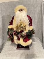 Full view of standing Santa on base with garland