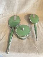 Full view of mirror, brush, powder jar showing green enamel and silver trim
