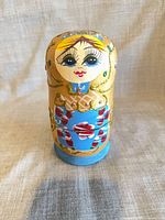 Front view of the largest blue and gold hand-painted wooden nesting doll