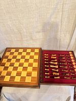 Open box showing inlaid board lid and interior compartments with pieces